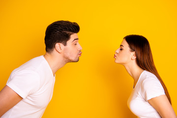 Obraz premium Close up side profile photo amazing beautiful she her he him his guy lady bonding ahead each other need kisses tenderness spread lips wear casual white t-shirts outfit isolated yellow background