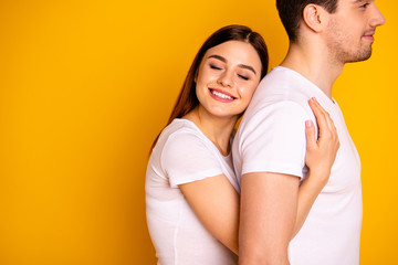 Close up side profile photo beautiful she her he him his guy lady pair hold tight close hands arms husband strong back eyes closed emotional wear casual white t-shirts isolated yellow background