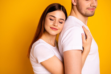 Cropped close up side profile photo beautiful she her he him his guy lady pair hold tight close hands arms husband strong back eyes closed relax wear casual white t-shirts isolated yellow background