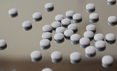  Tablets on a glossy metal surface. Tablets and vitamins for cats