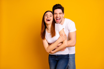 Portrait of his he her she two nice-looking lovely sweet attractive cheerful cheery positive people cuddling laughter isolated over vivid shine bright yellow background