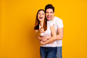 Portrait of his he her she two nice lovely attractive cheerful cheery positive people cuddling laughter pointing at you choose choice isolated over vivid shine bright yellow background