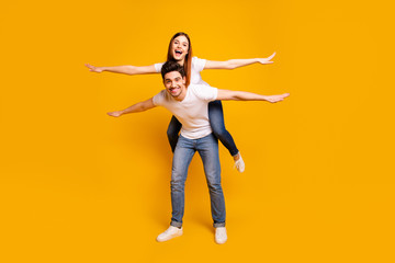 Fototapeta na wymiar Full length body size view portrait of his he her she two nice attractive cheerful cheery optimistic people having fun trip fly isolated over vivid shine bright yellow background