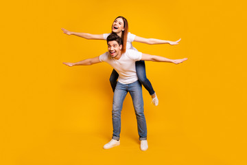Fototapeta na wymiar Full length body size view portrait of his he her she two nice attractive cheerful optimistic people having fun trip fly vacation holiday isolated over vivid shine bright yellow background