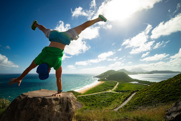 Masculine man standing on his hand on the Miami beach