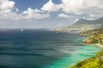 Aerial view of cruise ship near Caribbean island with green mountains