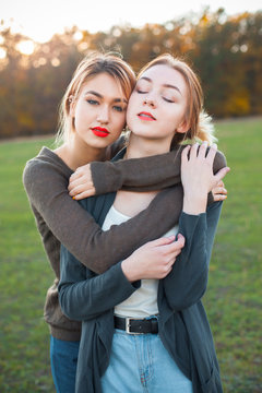Two young female hugging outdoors. Best friends