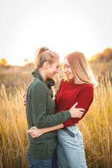 Two young women hugging outdoors at evening. Best friends