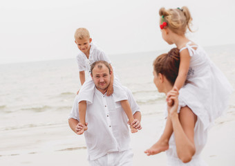 Happy young family on the sunset at the beach.