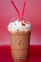 Iced chocolate cocoa and whip cream on top with red tubes