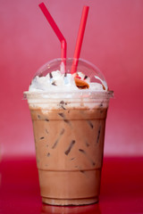 Iced chocolate cocoa and whip cream on top with red tubes