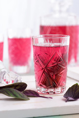 Turkish ramadan drink Sherbet with sweet basil, sugar and cinnamon on white background in cut glass.