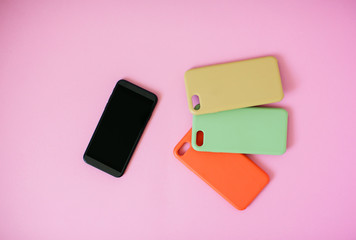 Top view of a smartphone with headphones and charge and silicone cases.