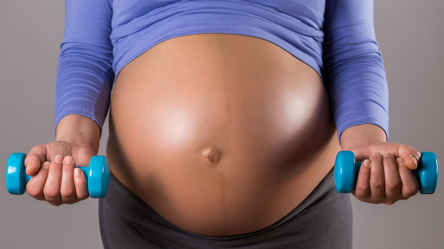 Image of close up stomach of woman exercise with weights on gray background.