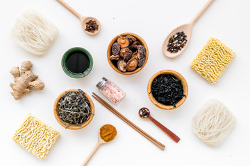 Chinese and Japanese food cooking with ginger, spices and noodles on white background top view geometric pattern