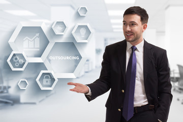 The concept of business, technology, the Internet and the network. A young entrepreneur working on a virtual screen of the future and sees the inscription: Outsourcing