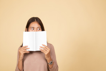 Fototapeta premium Young Asian woman with a book cover her face.