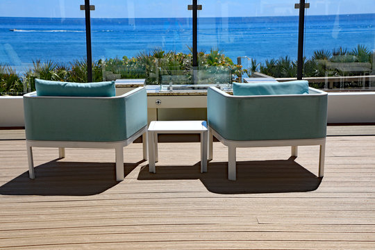 Inviting designer patio furniture on an oceanfront terrace in South Florida.