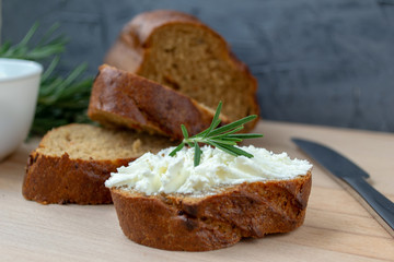 Sliced bread with light cheese on a wooden board.