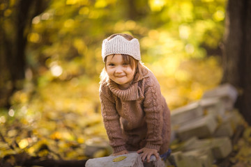 girl child plays in the forest in knitted tunic