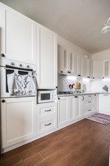 Modern white kitchen, gas stove with electric oven, clean design. Kitchen interiors