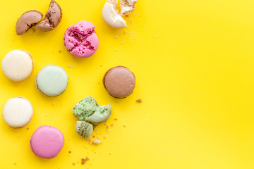 Macarons dessert pattern on yellow background top view copy space