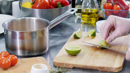 A chef working in the kitchen. Cutting the lime. Cut off the peel