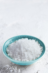 Ceramic bowl of salt on a marble background. Copy space