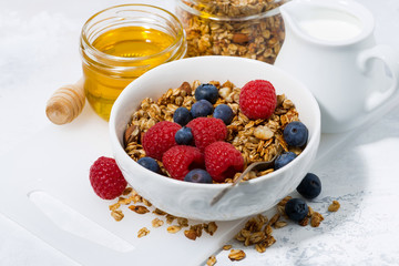 fresh cottage cheese with granola and honey on white table, closeup