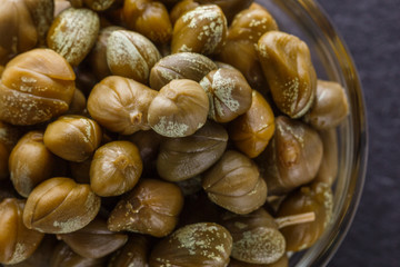 pickled capers on a dark stone background