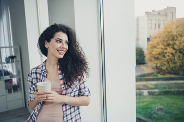 Portrait of her she nice-looking winsome fascinating sweet attractive lovely charming cute cheerful dreamy wavy-haired girl looking at window in light white interior room