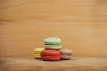 Colorful tasty french macarons isolated on wood texture