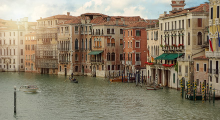 Venetian gondola and boats in big canal waters of Venice Italy.