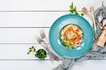Pasta with pineapple and carrots. In the plate. Top view. Free space for your text. Rustic style.