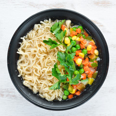 Asian soup with noodles and vegetables in a bowl, with toast bread. Dietary food. Top view. Free copy space.