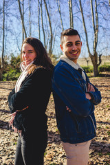 Fototapeta premium Happy young couple smiling together in a sunny forest on an autumn day.