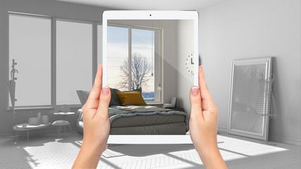 Hands holding tablet showing modern scandinavian bedroom, total blank project background, augmented reality concept, application to simulate furniture and interior design products