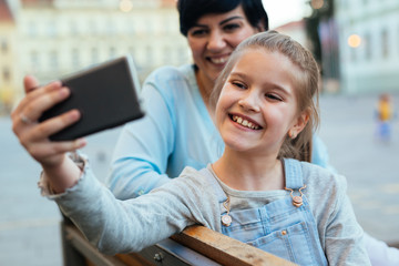girl taking sefie with her mom in the city