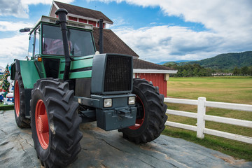 A retro tractor parked next to a barn in a farm.Thailand.
