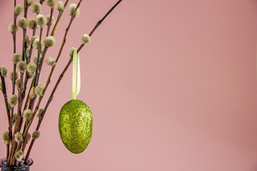 Willow twigs and hanging on them painted Easter egg on the ribbon. Background about Easter. Copy space