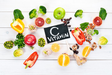 Obraz na płótnie Canvas Food containing natural vitamin C: Orange, lemon, apple, rose, garlic, broccoli, apple, kiwi, spinach. Top view. On a white background.
