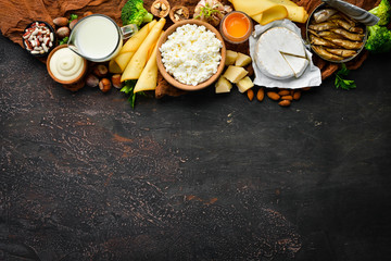 Obraz na płótnie Canvas Dietary food. Healthy food: cheese, milk, parmesan, sour cream, fish, almonds, parsley, garlic, broccoli. Top view. Free copy space.