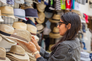Young indian woman buying hats