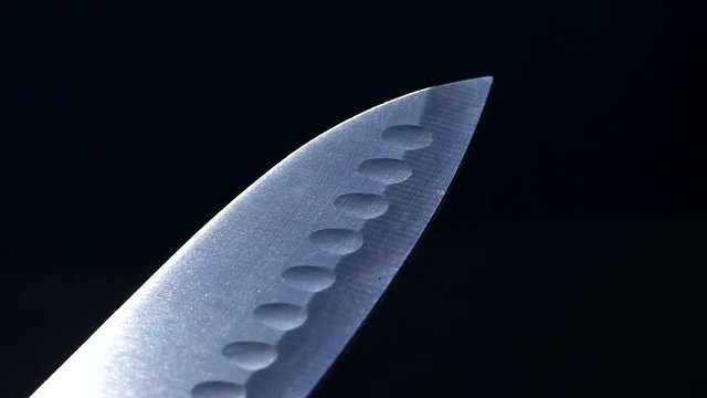 The reflection of the blade knife Santoku. Cold steel in the kitchen.