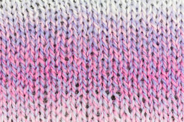 knitted fabric background with stockinette stitch pattern in pink, purple and white