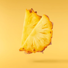 Flying in air fresh ripe whole and cut baby Pineapple with slices and leaves