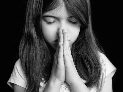 Cute little girl praying, black and white photo