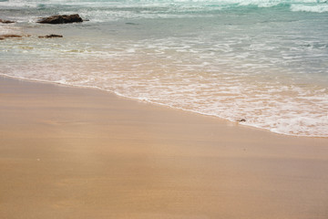 Blue ocean wave on the blond sandy beach. Heavenly background.