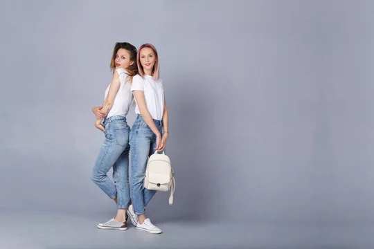 Hipster girl wearing blank gray t-shirt, jeans and backpack posing