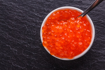 red caviar in a bowl on a dark stone background